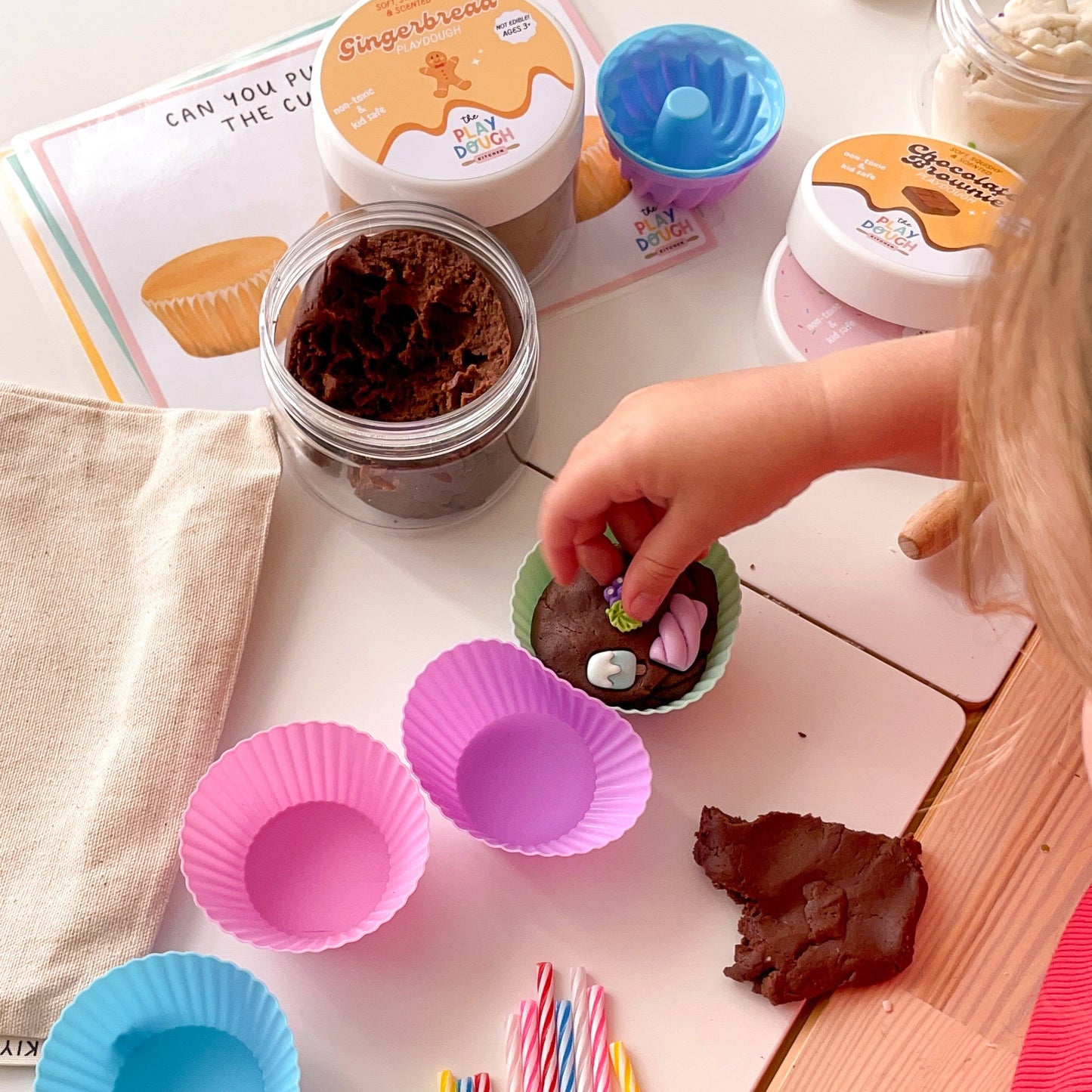 Child playing with play dough and utensils on a table