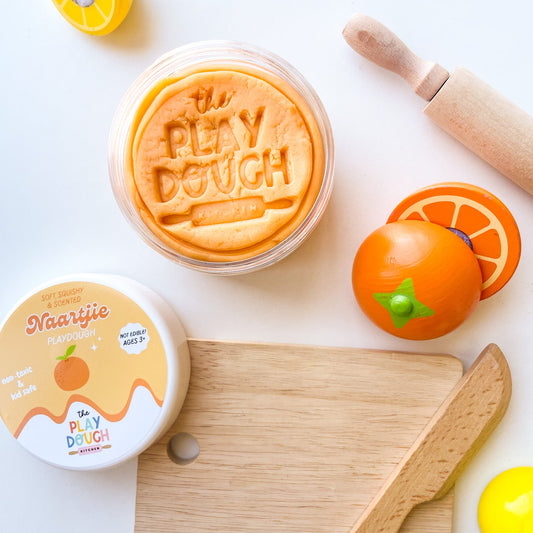 Orange playdough in a jar stamped with 'The Playdough Kitchen'