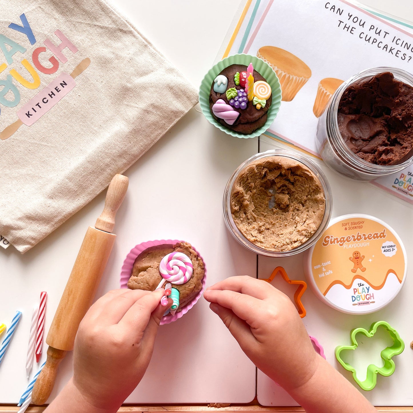 Children's play dough kitchen set with play dough, tools, and a child makig a cupcake.