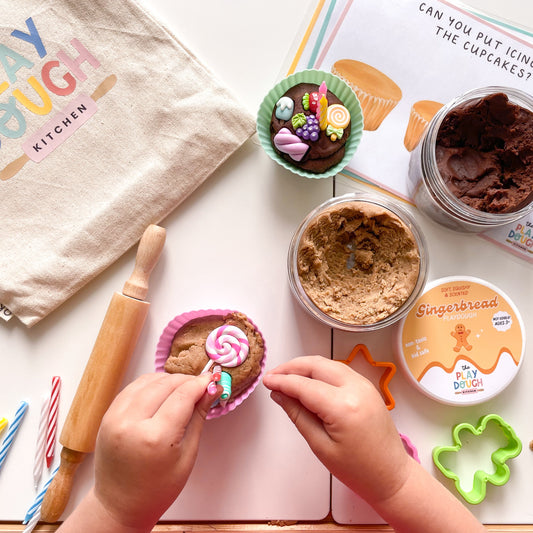 Children's play dough kitchen set with play dough, tools, and a child makig a cupcake.