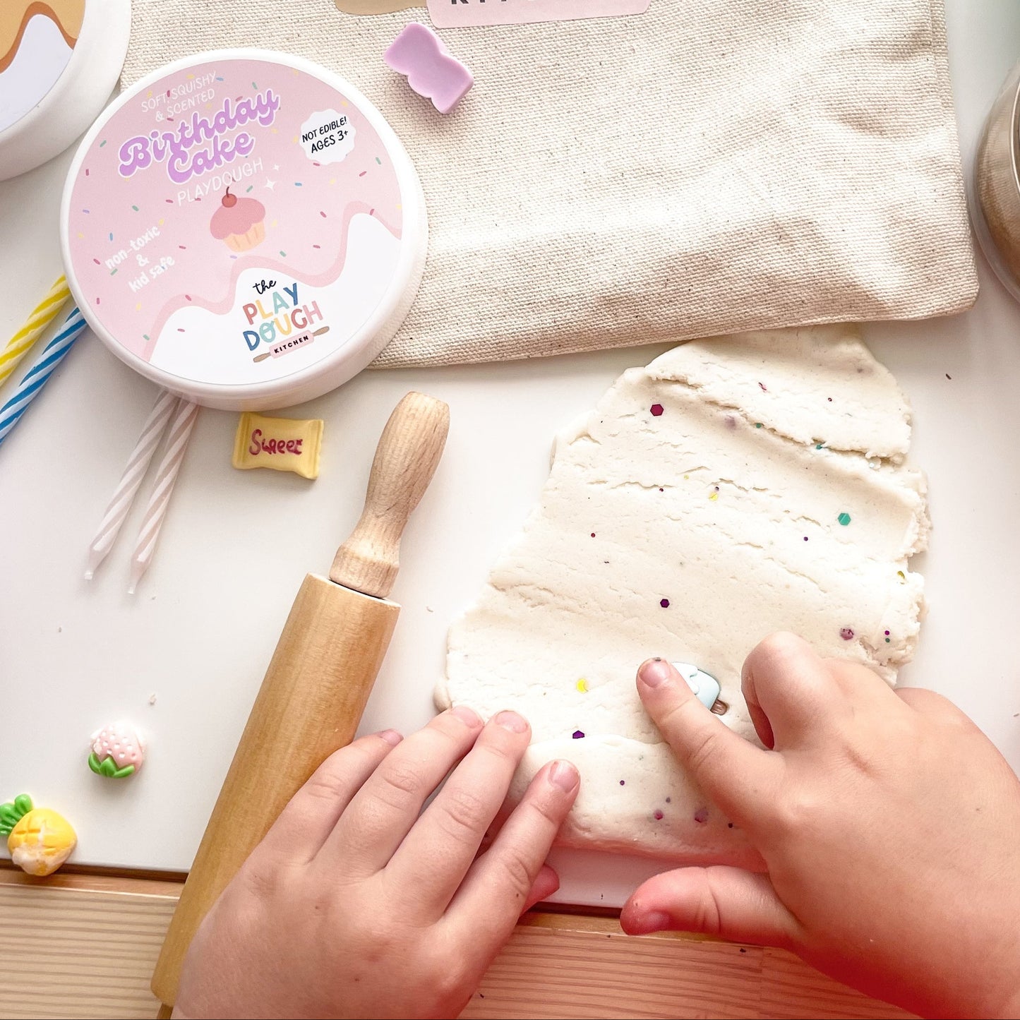 Birthday cake playdough with colourful glitter rolled out with a rolling pin