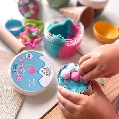 Child playing with colourful play dough and tools on a table