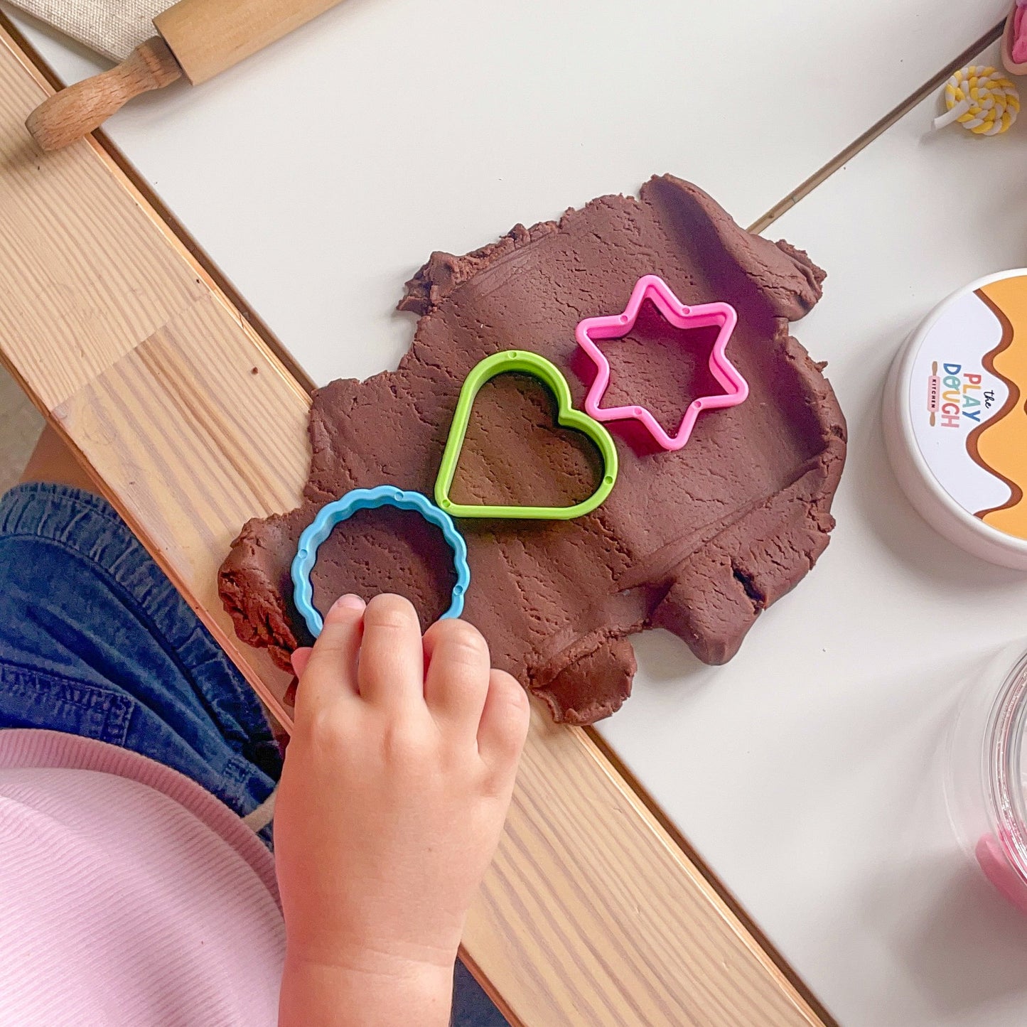 Chocolate playdough rolled flat with a star, circle and heart cookie cutter pressed into it
