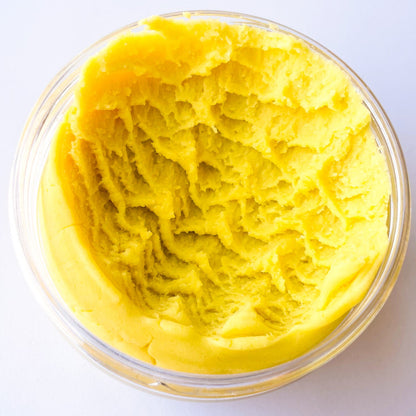 A jar of yellow play dough in a clear jar on a white surface