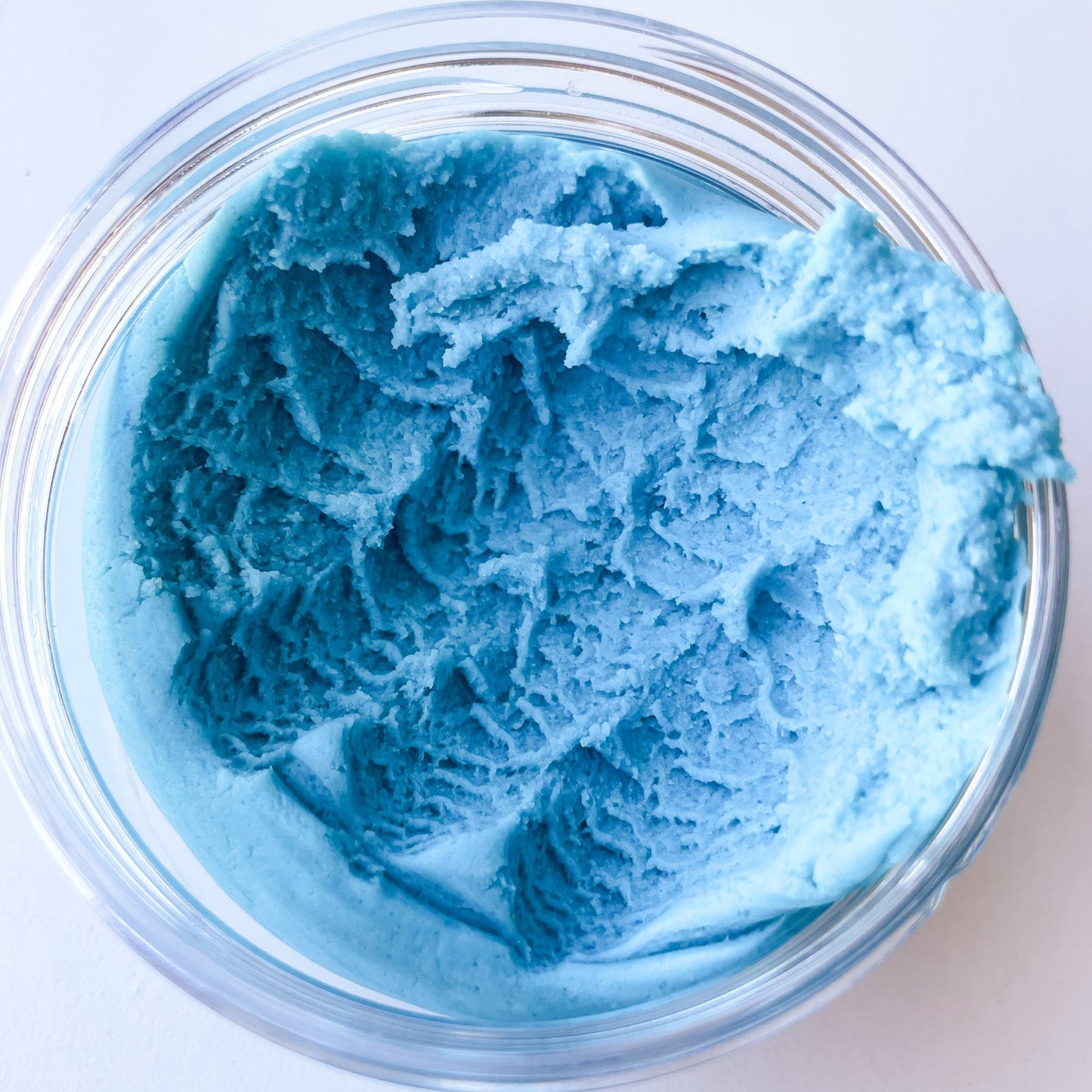Blue playdough in a jar on a white background